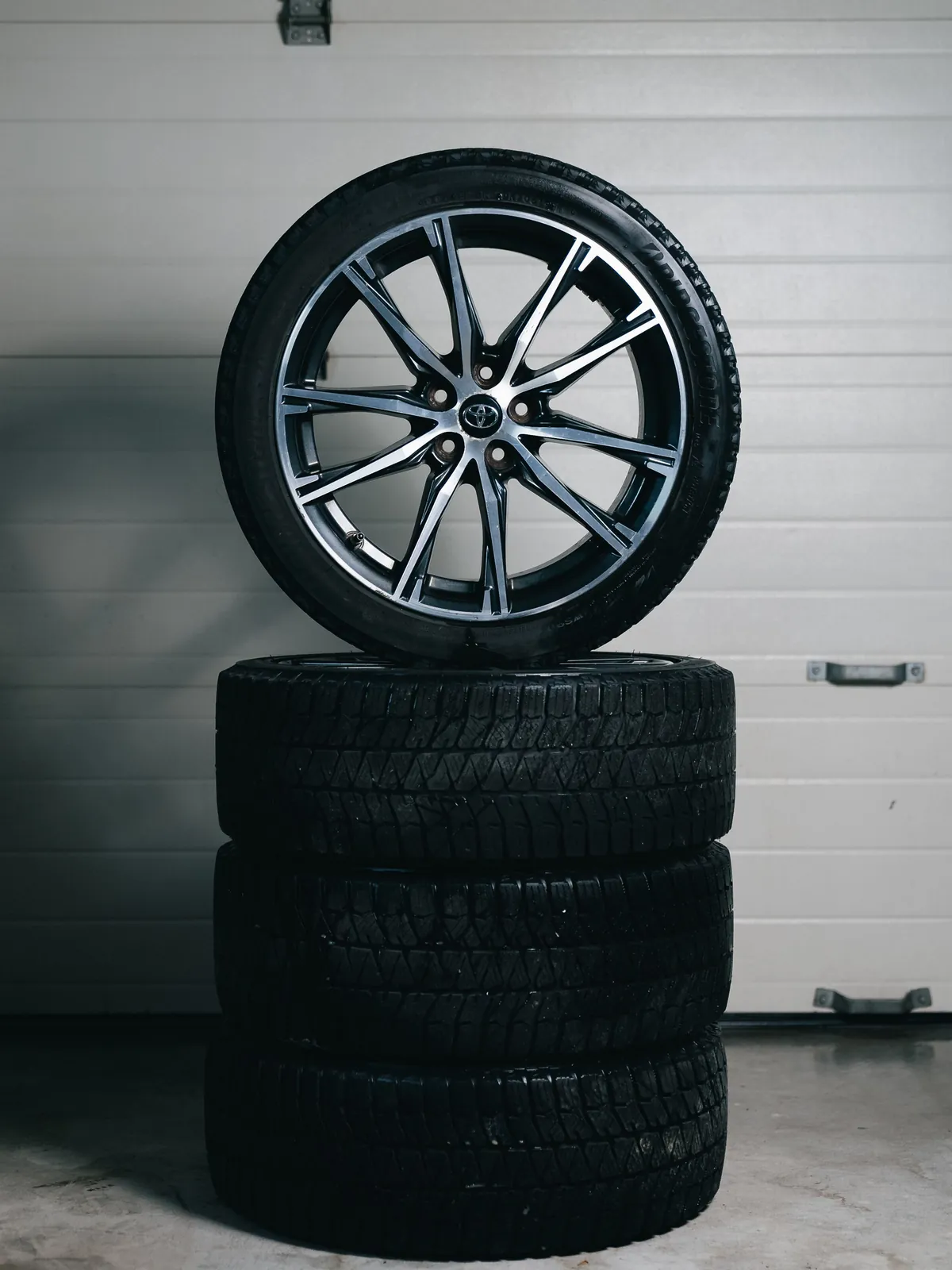 Wheel with an alloy rim on a stack of winter tires
